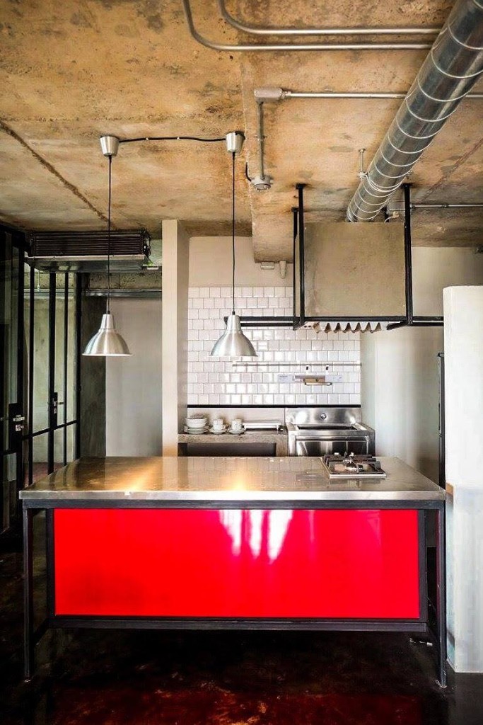 Industrial-style shared kitchen with stainless steel countertop and red accent